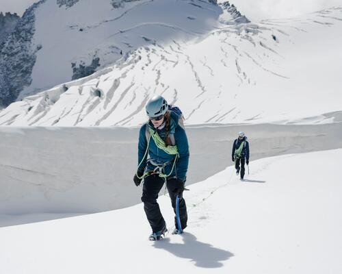 kobieta i mężczyzna w zimowej odzieży  trekkingowej wędrujący po śniegu w górach