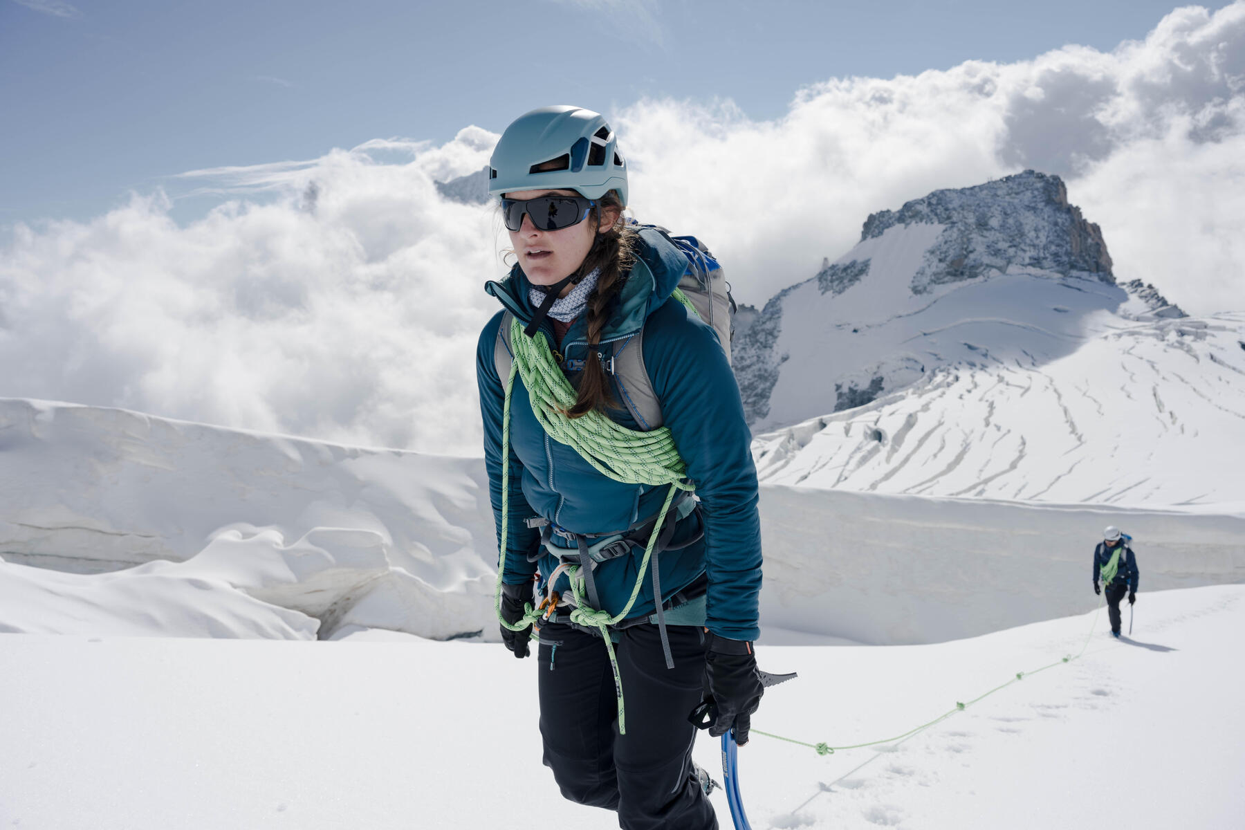 Kobieta w kasku i odzieży alpinistycznej wędrująca po górach uprawiając himalaizm