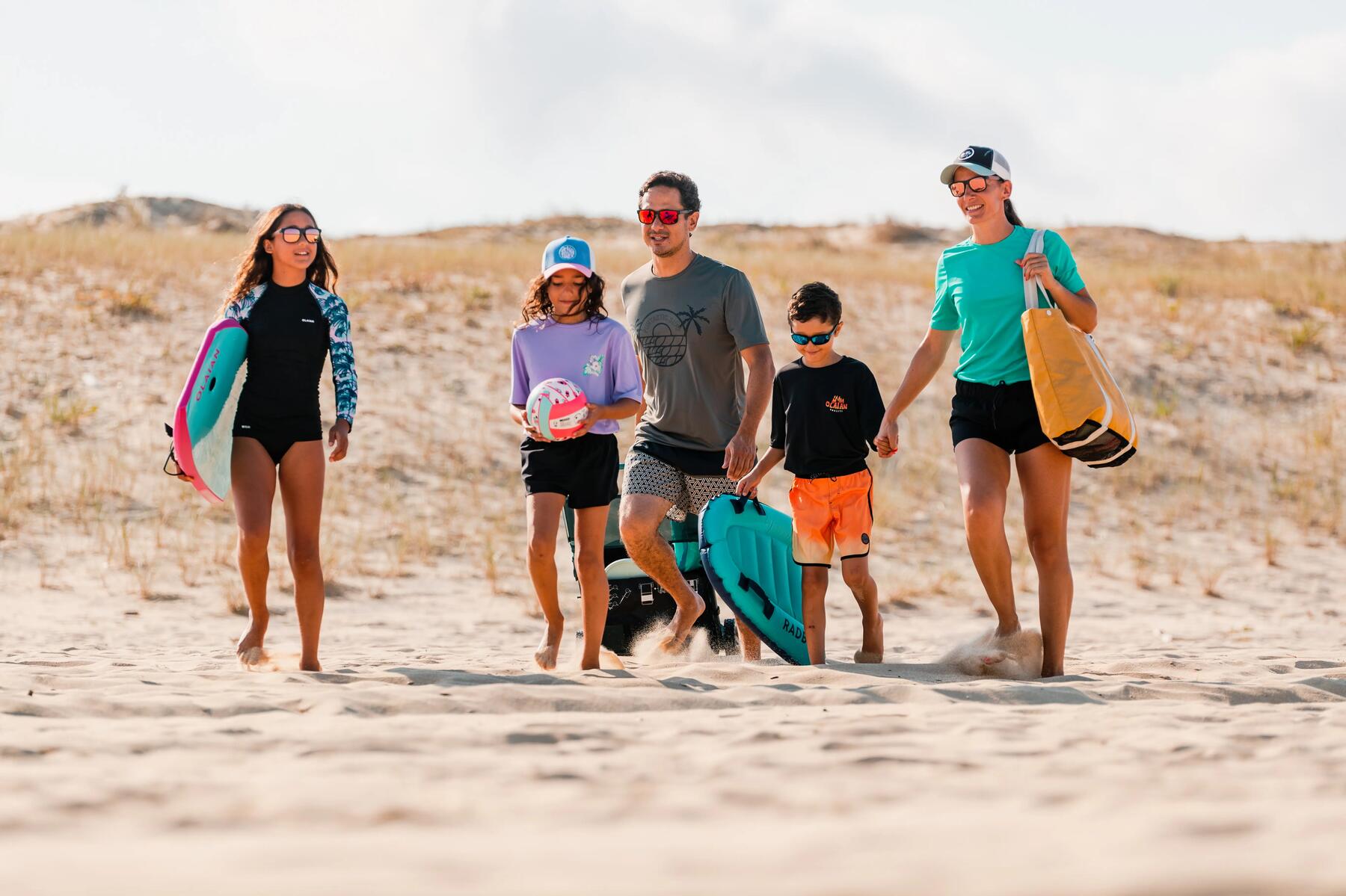 familia en la playa con gorra y gafas de sol