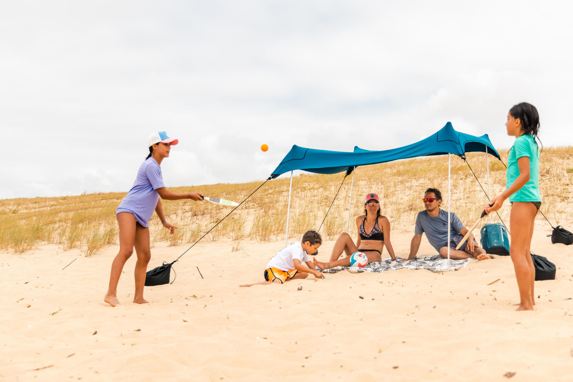 Rodzina spędzająca czas na plaży na kocu piknikowym