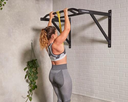 Kobieta próbująca zrobić muscle up na drążku