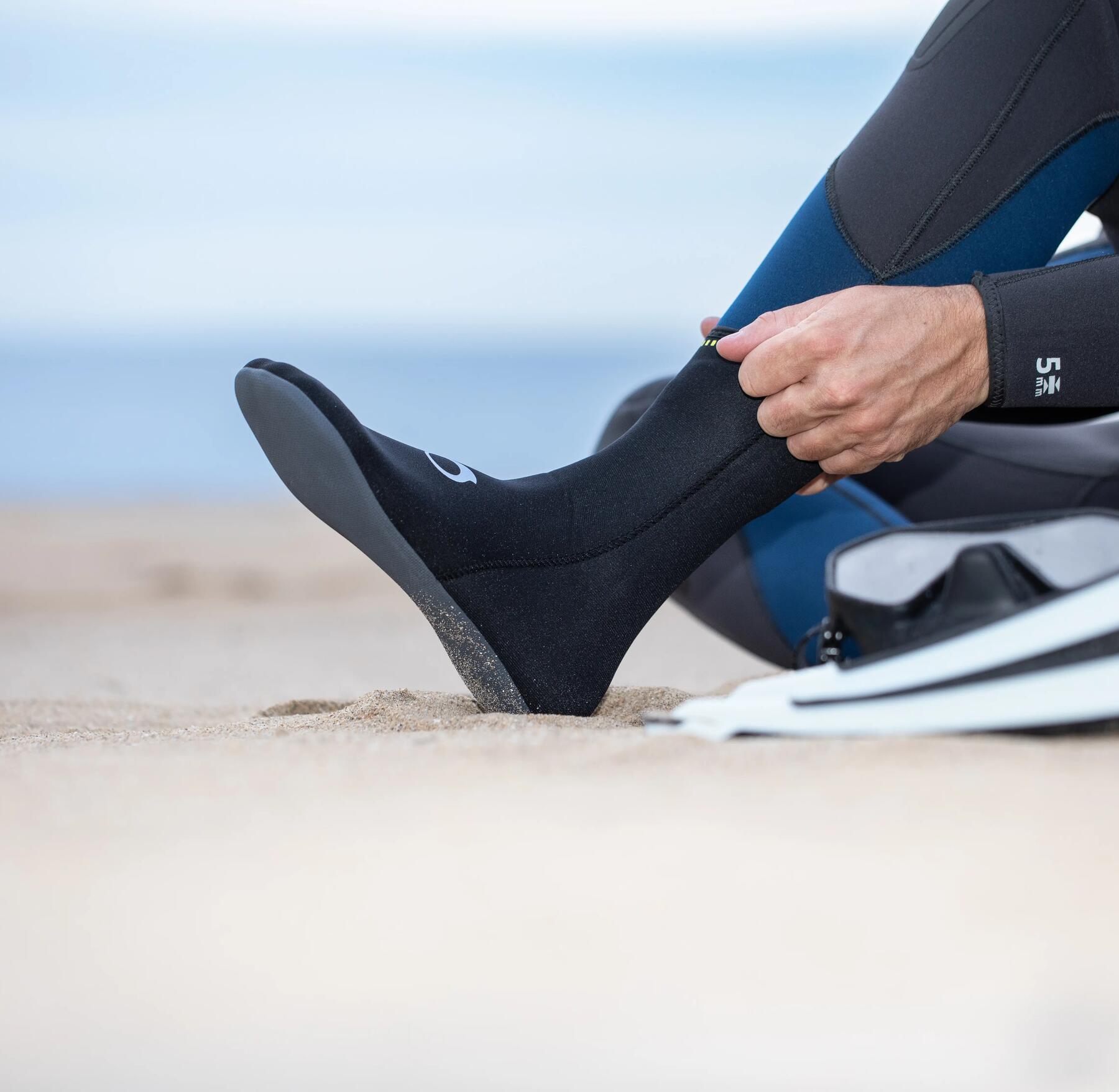Mężczyzna zakładający buty neoprenowe do morosowania