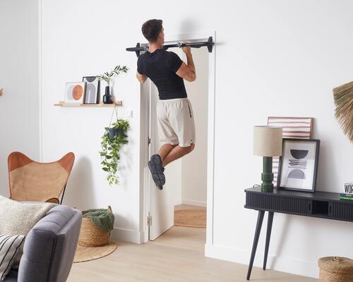 A man using a pull up bar at home