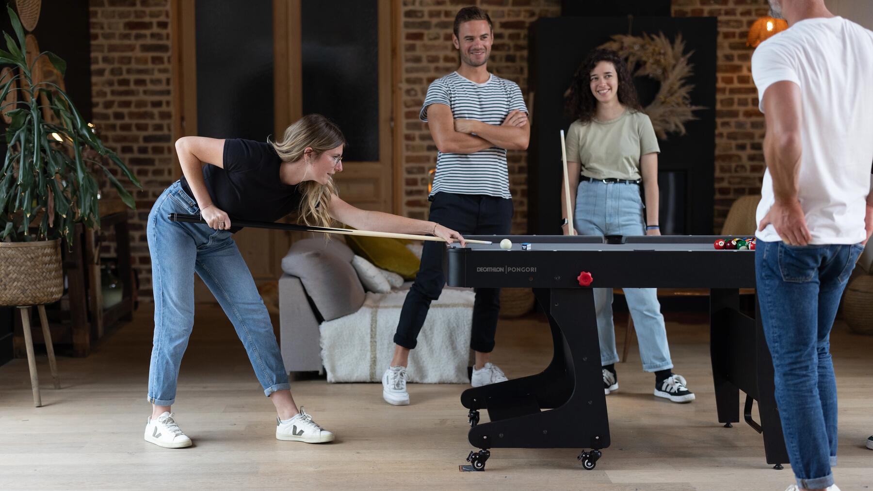 Kobieta celująca kijem bilardowym w białą kulę podczas rozgrywki 9-ball