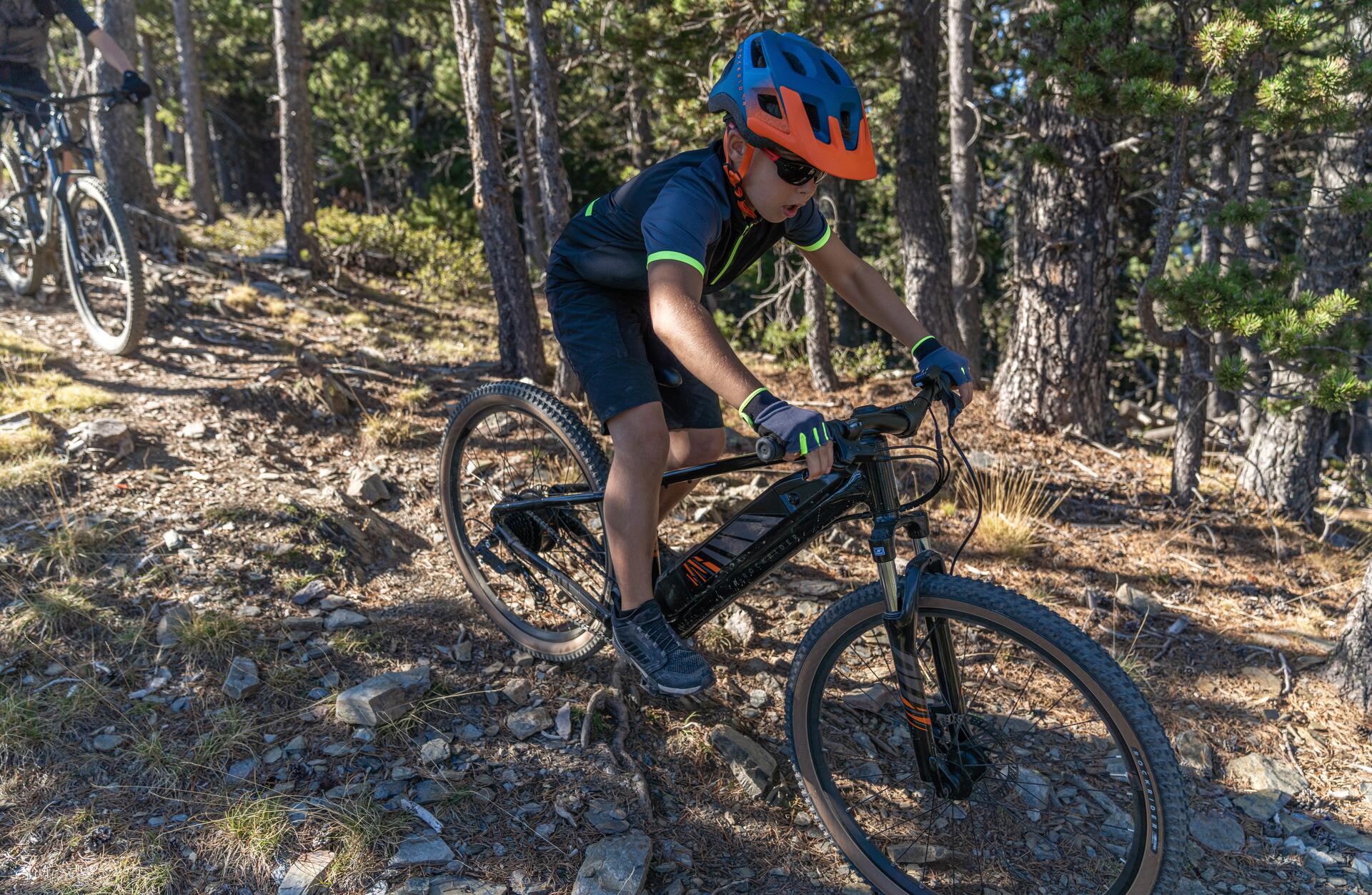 chłopiec w kasku jadący na rowerze górskim