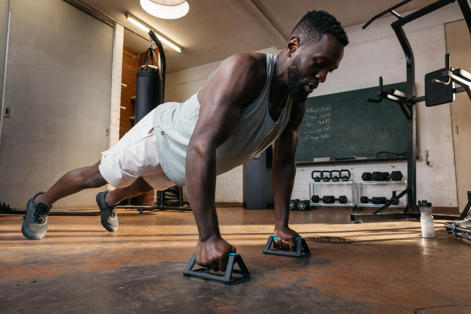 Mężczyzna ćwiczący na uchwytach do pompek plank