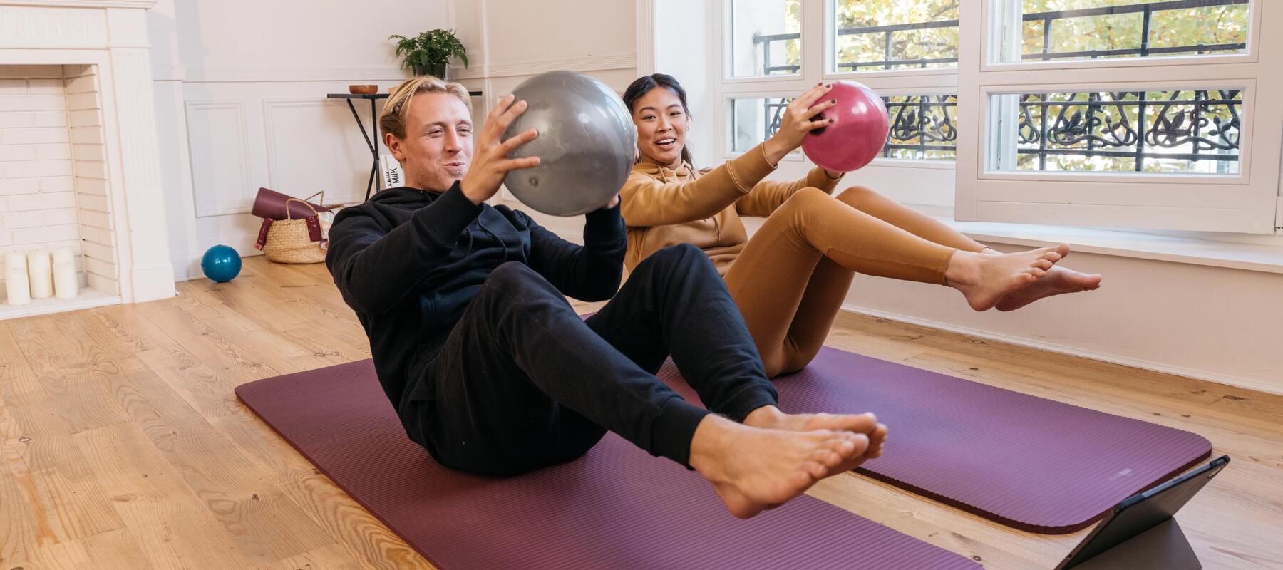 A man and women working out at home with a medicine ball