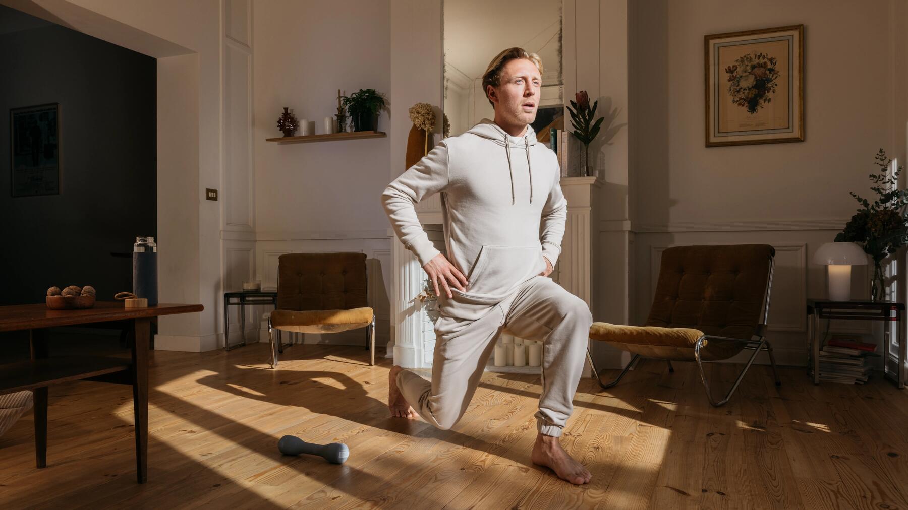 Mężczyzna w dresie wykonujący stretching w domu