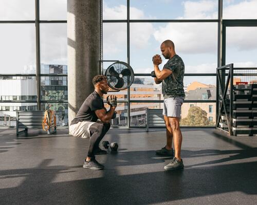 mężczyźni w odzieży fitness trenujący z hantlami 