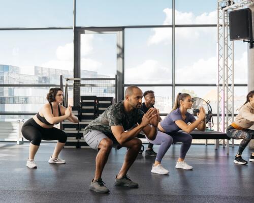 kobiety i mężczyźni trenujący w odzieży fitness 