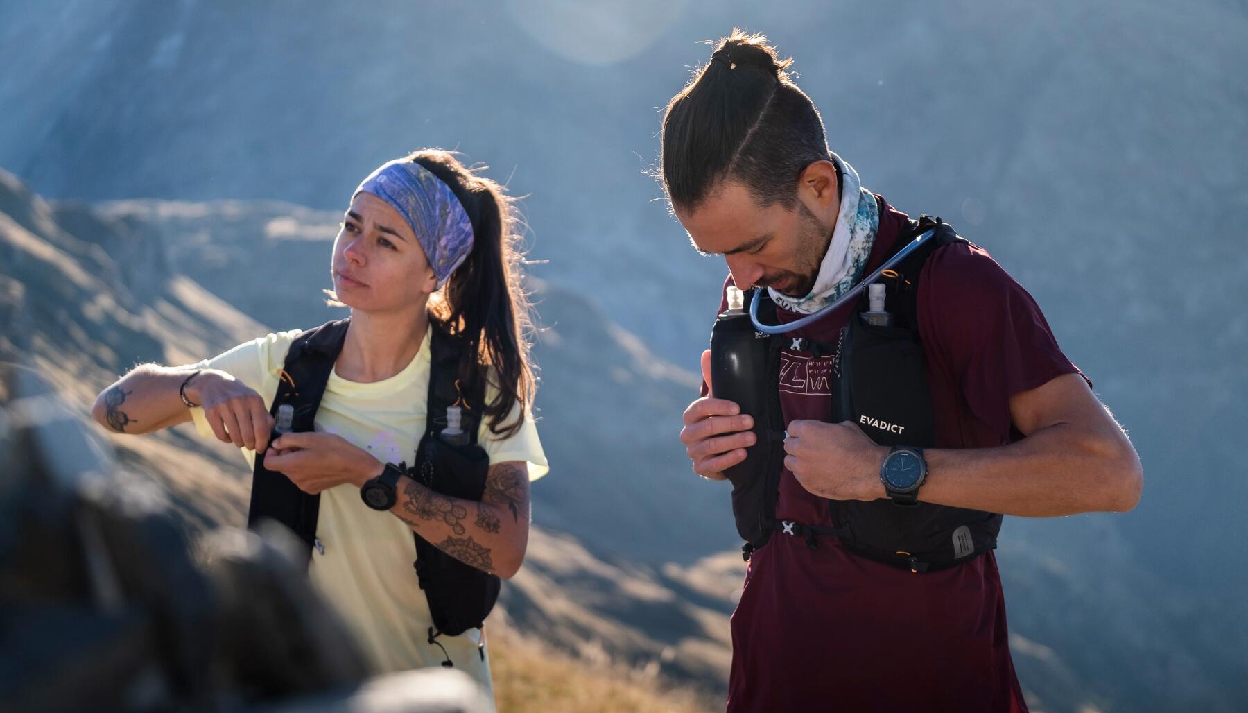 man and woman adjusting their running vests