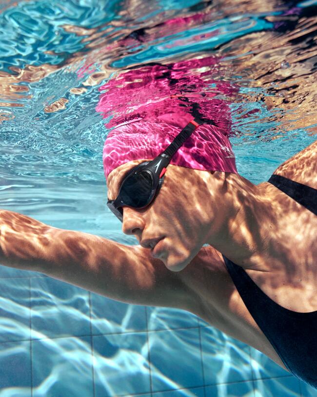 Frau schwimmt in Schwimmbecken, Schwimmbrille Speedo, Badekappe, Badeanzug
