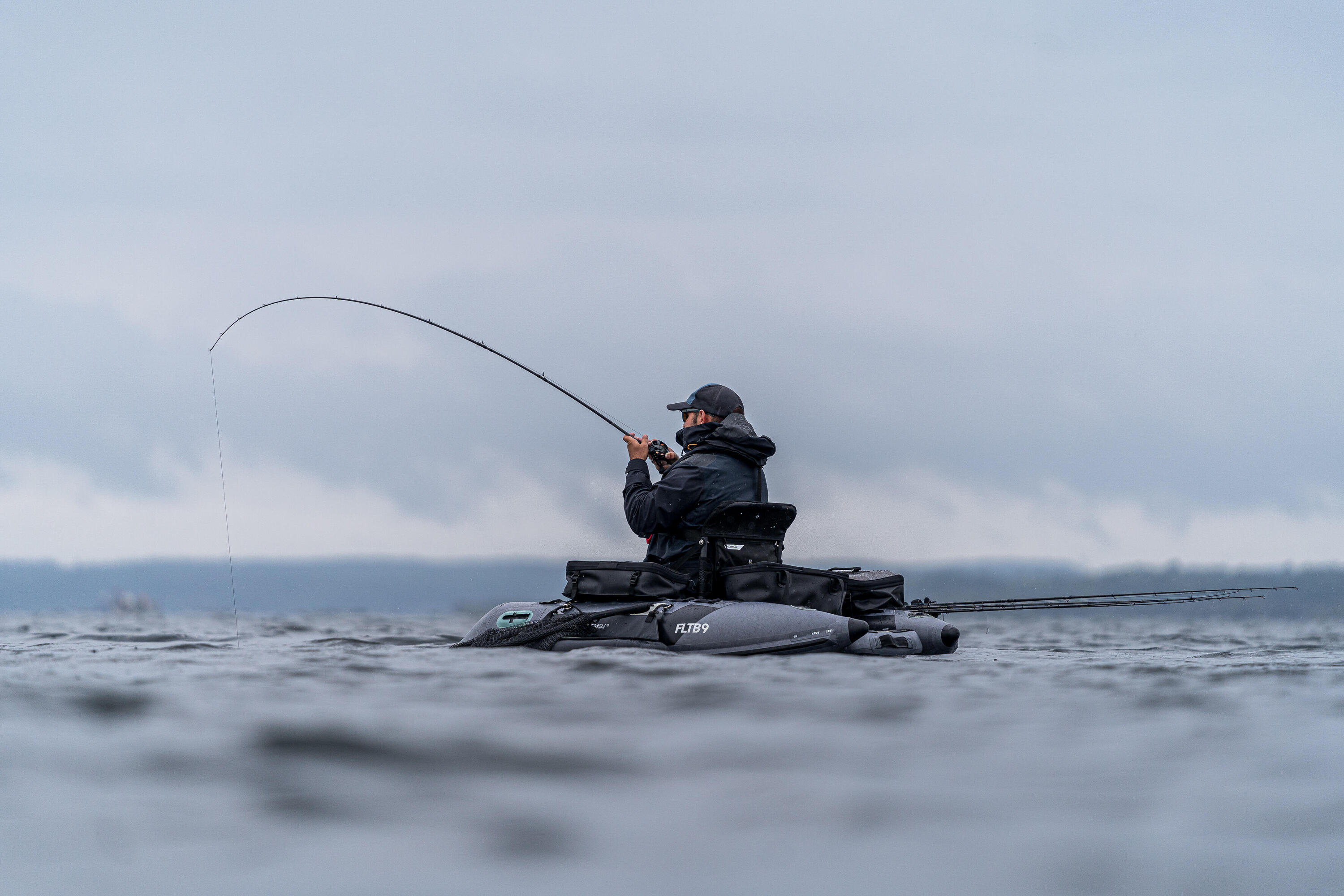Pescatore su un belly boat in un lago
