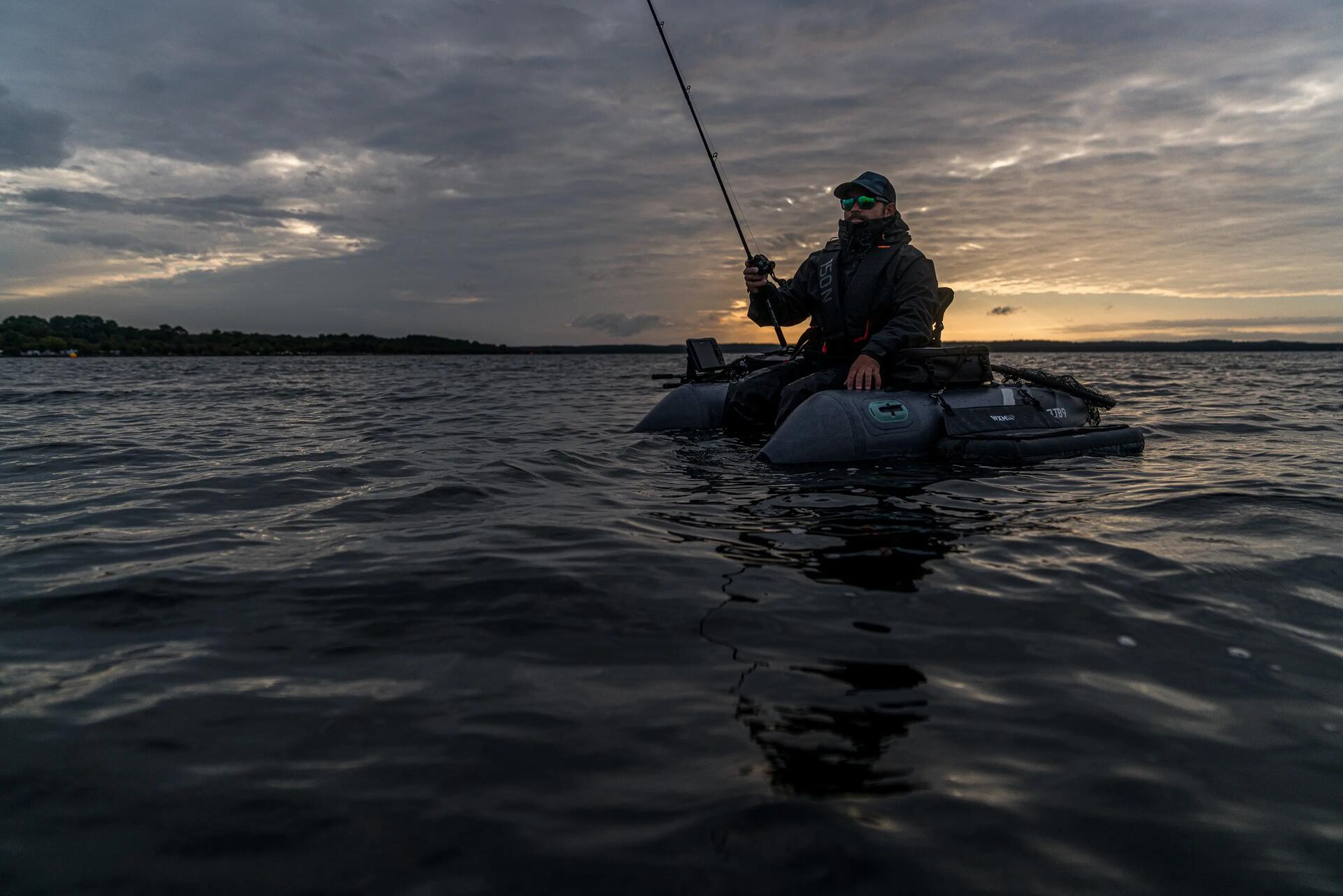 Pêcheur à la recherche des poissons en float tube sur un grand lac 