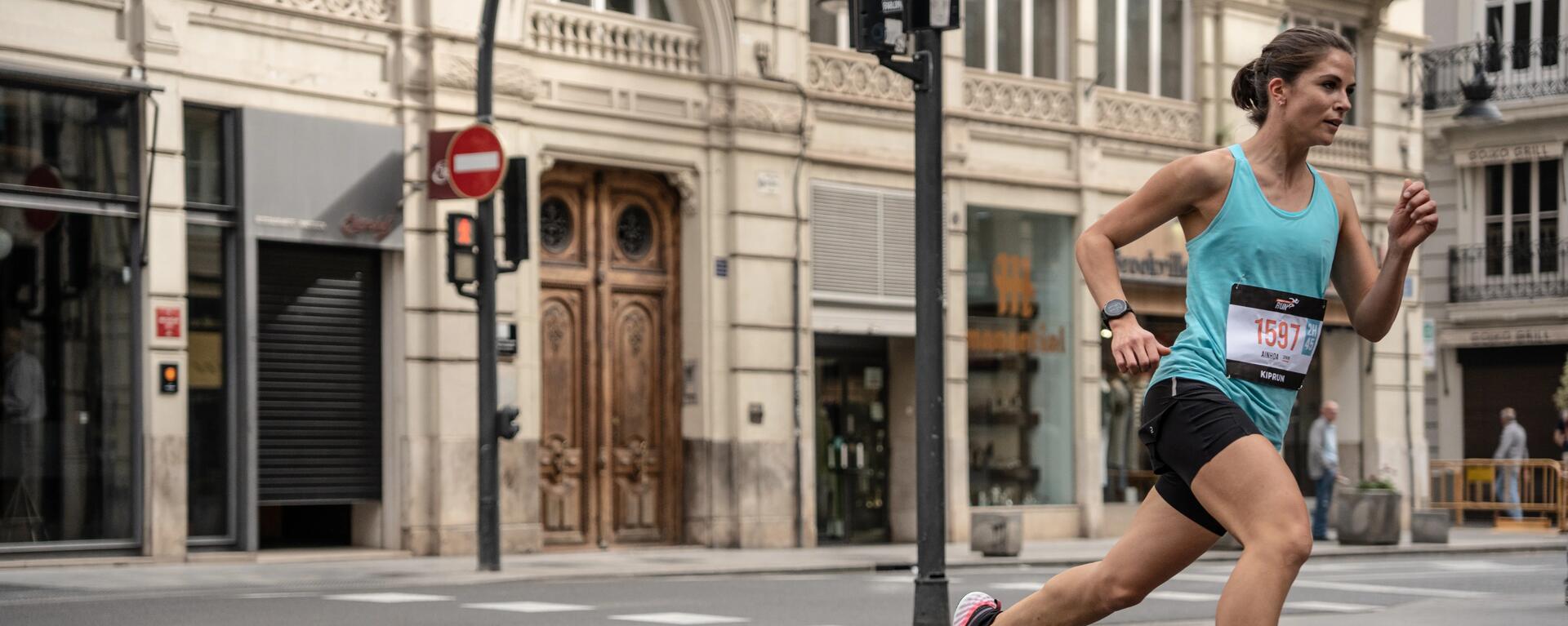 Uczestniczka maratonu biegnąca w odzieży do biegania w mieście