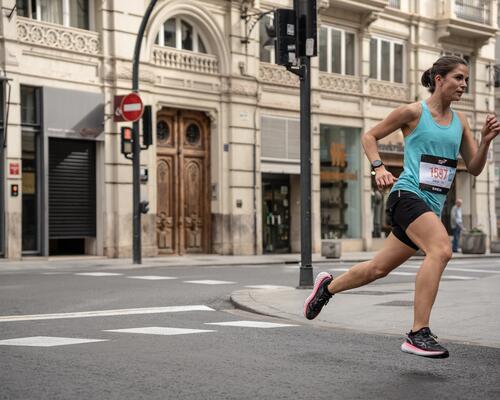 Uczestniczka maratonu biegnąca w odzieży do biegania w mieście