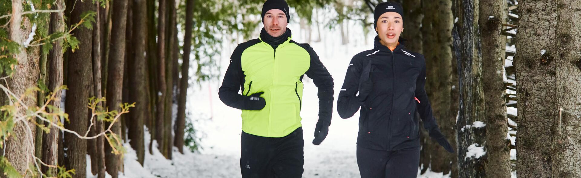 mężczyzna i kobieta biegnący zimą w czapkach i strojach do biegania