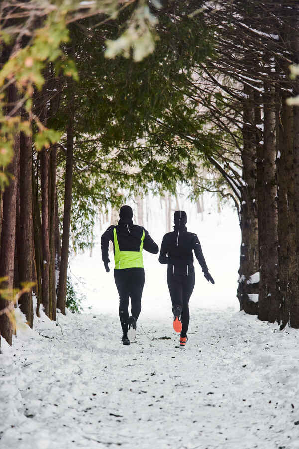 Two people running in the snow