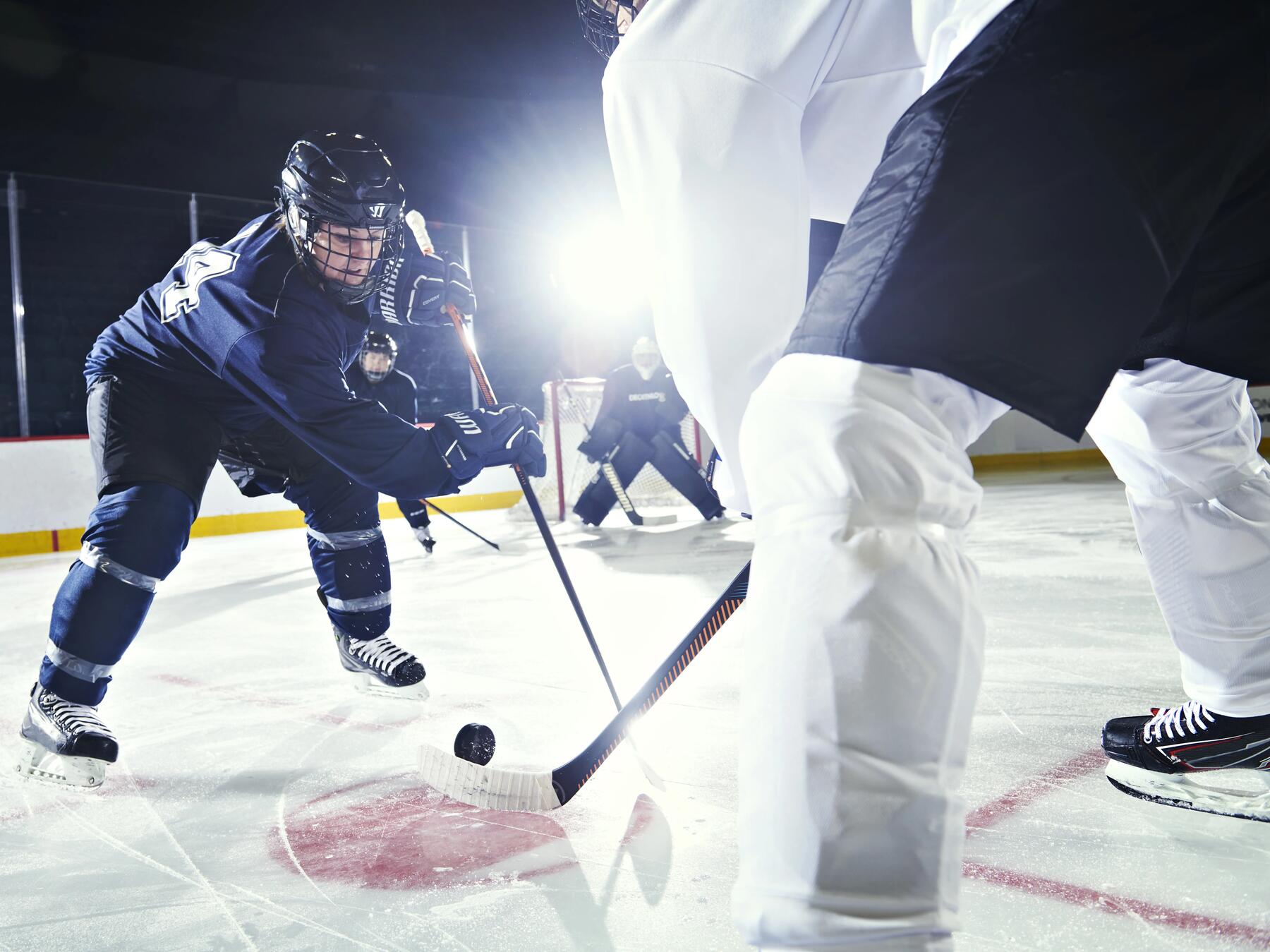 gracze w odzieży i kaskach hokejowych na lodowisku
