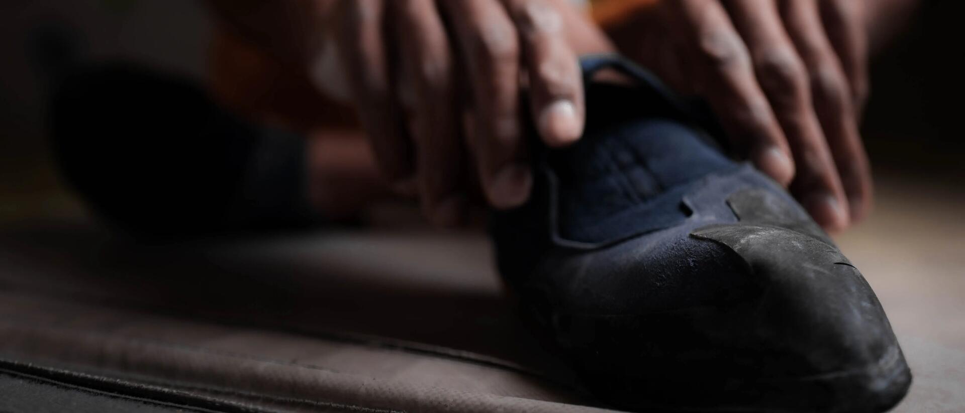 mężczyzna zakładający buty do wspinaczki