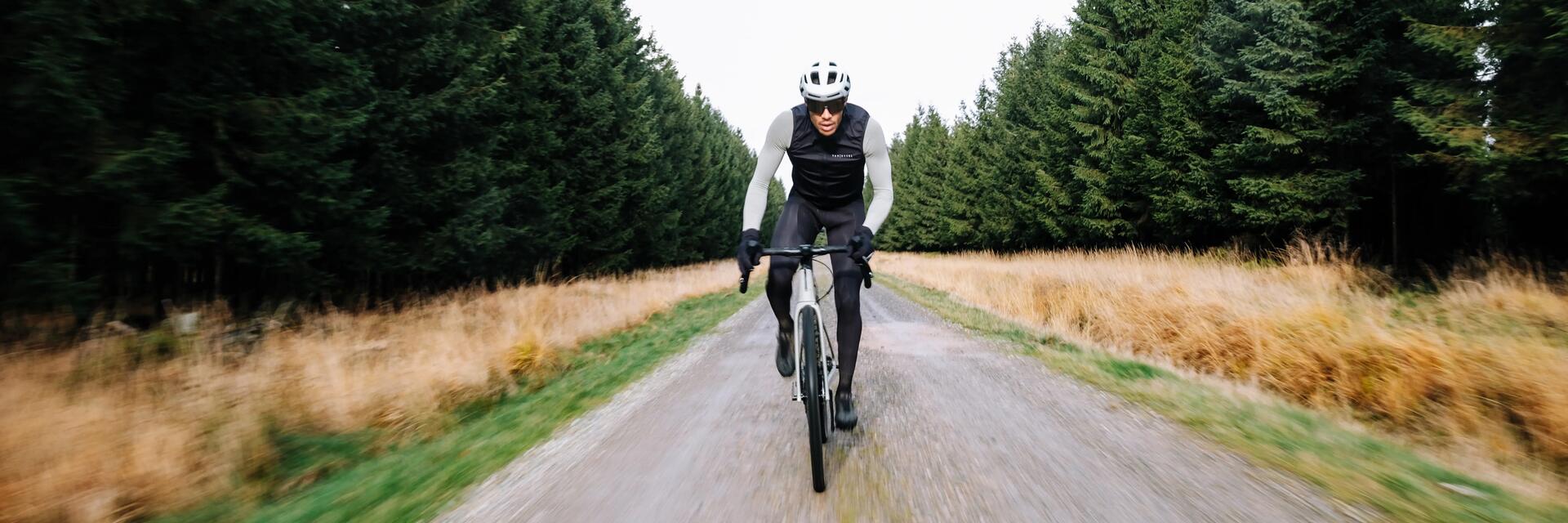 mężczyzna jadący na rowerze typu gravel w kasku i okularach rowerowych