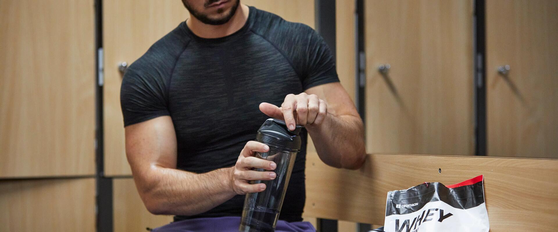 Man holding water bottle in changing room