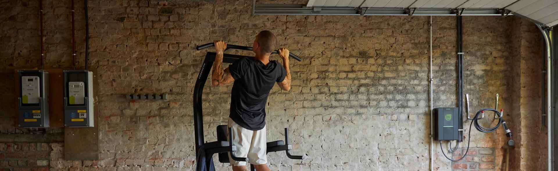 mężczyzna w odzieży fitness podciągający się na drążku
