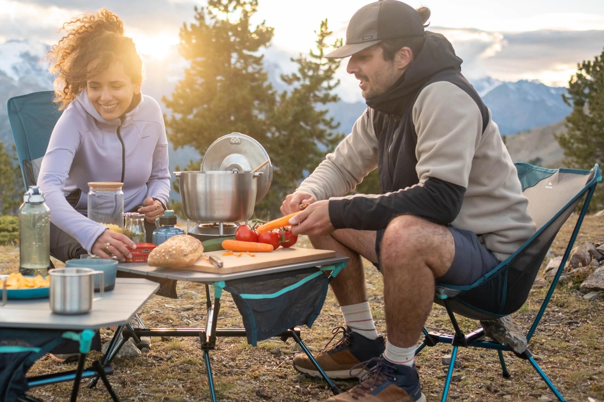 Kobieta z mężczyzną przygotowujący kolacje na campingu