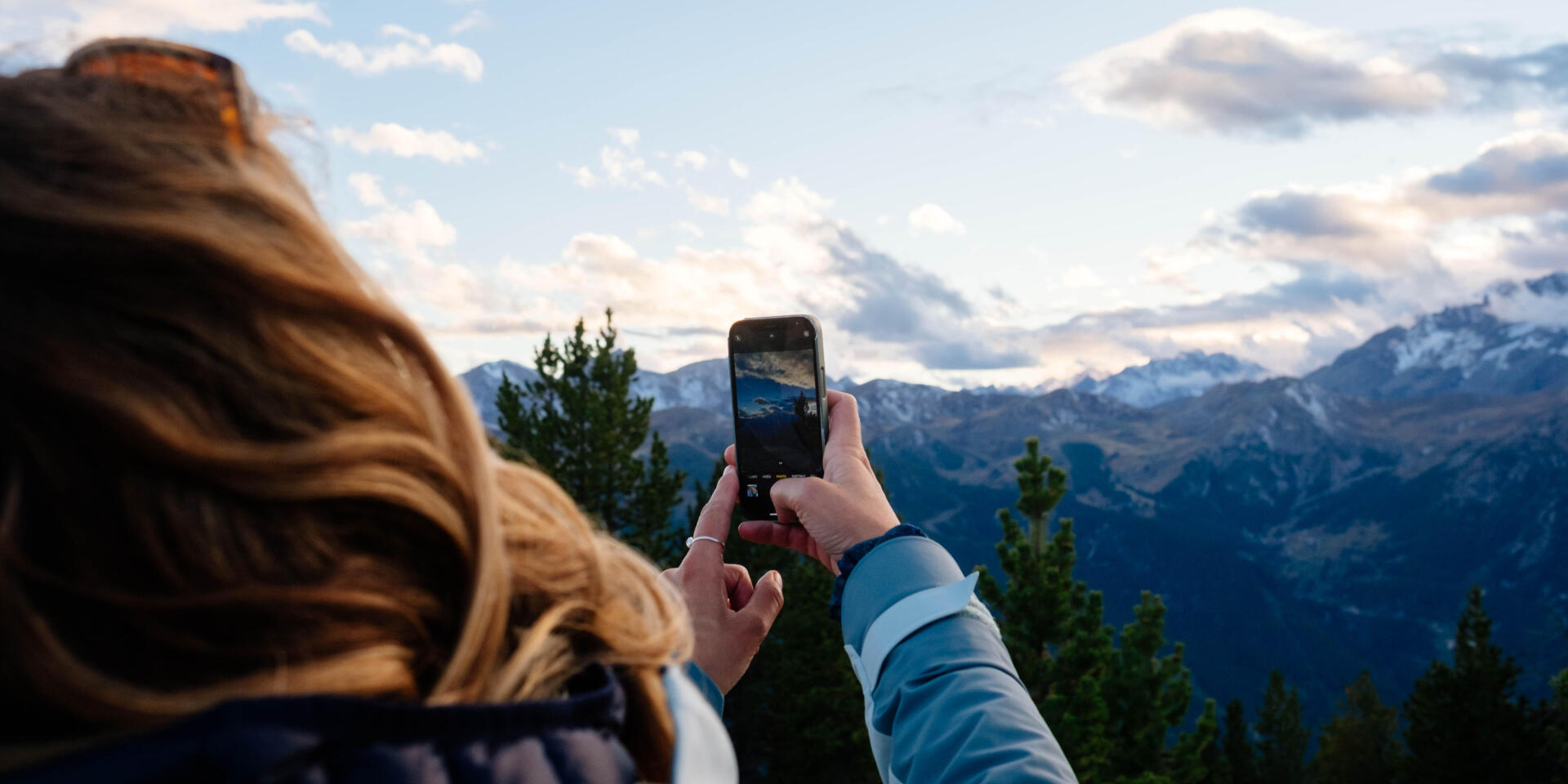 femme qui prend en photo un paysage de montagnes