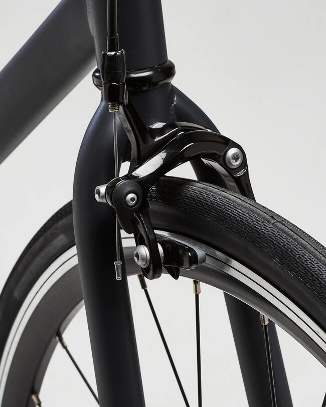 Gelbes sportliches Fahrrad vor grauem Rolltor; industrielles Ambiente