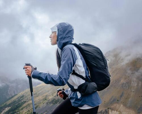 kobieta wędrująca po górach w kurtce trekkingowej z kapturem