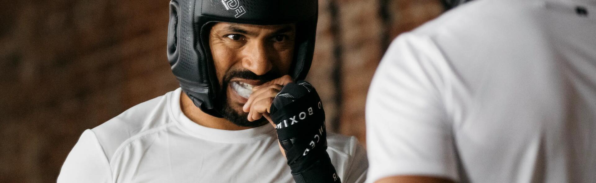 mężczyzna wkładający ochraniacz na zęby do trenowania boksu 