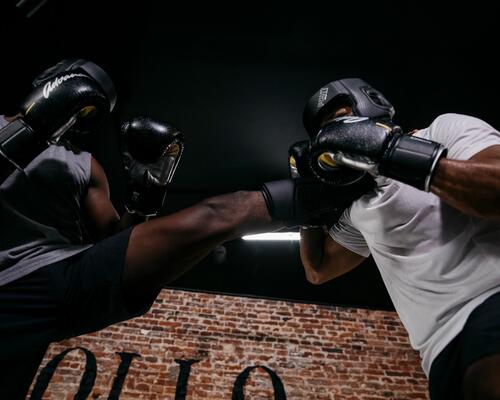 Two men boxing, wearing gloves and headgear