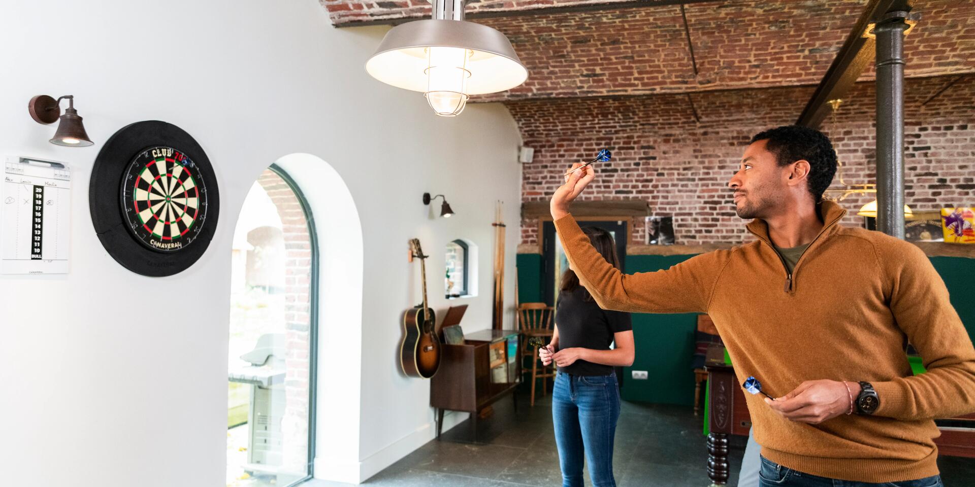 Man throwing dart at dartboard