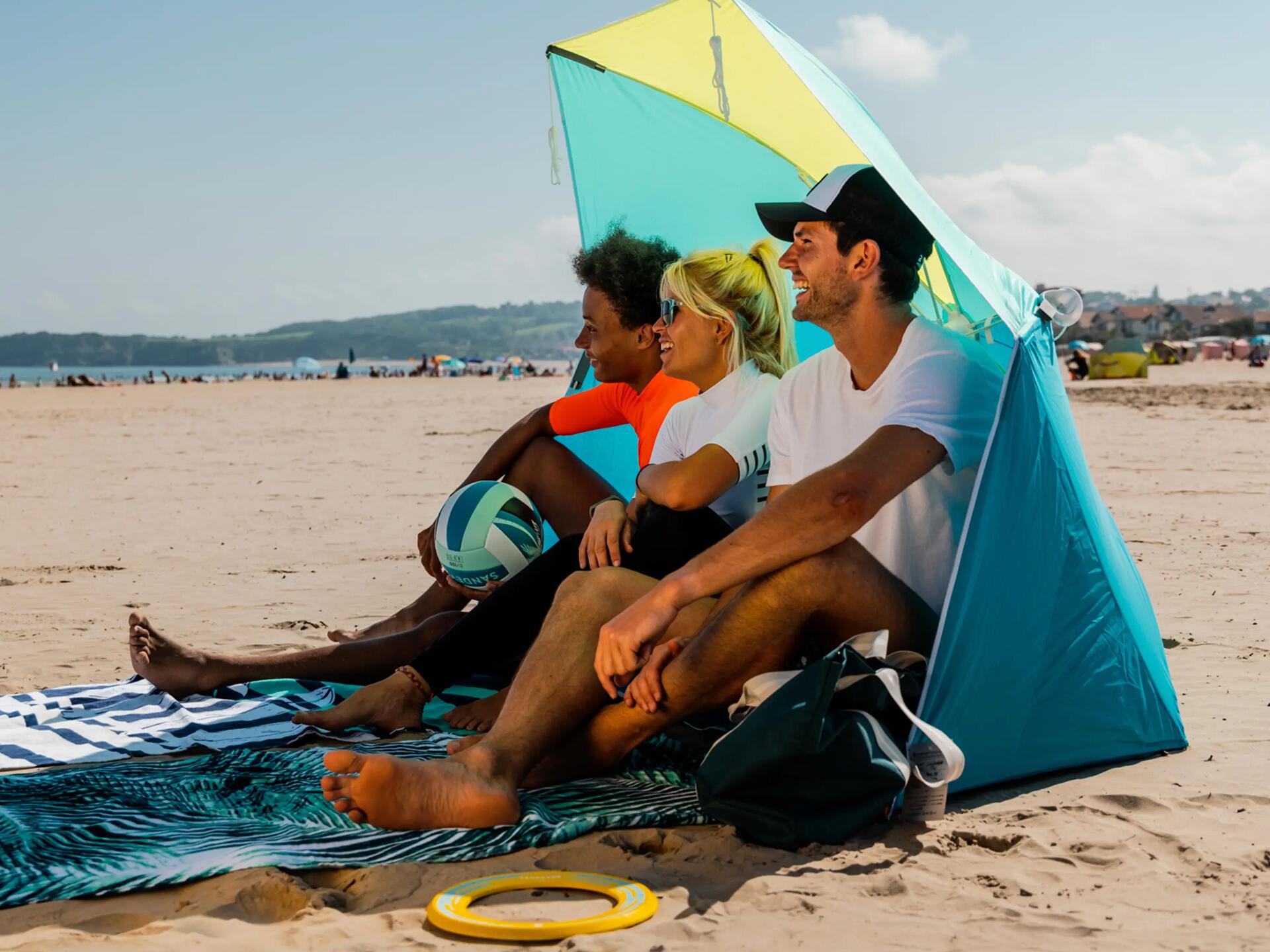 Mężczyzna siedzący na plaży w czapce z daszkiem