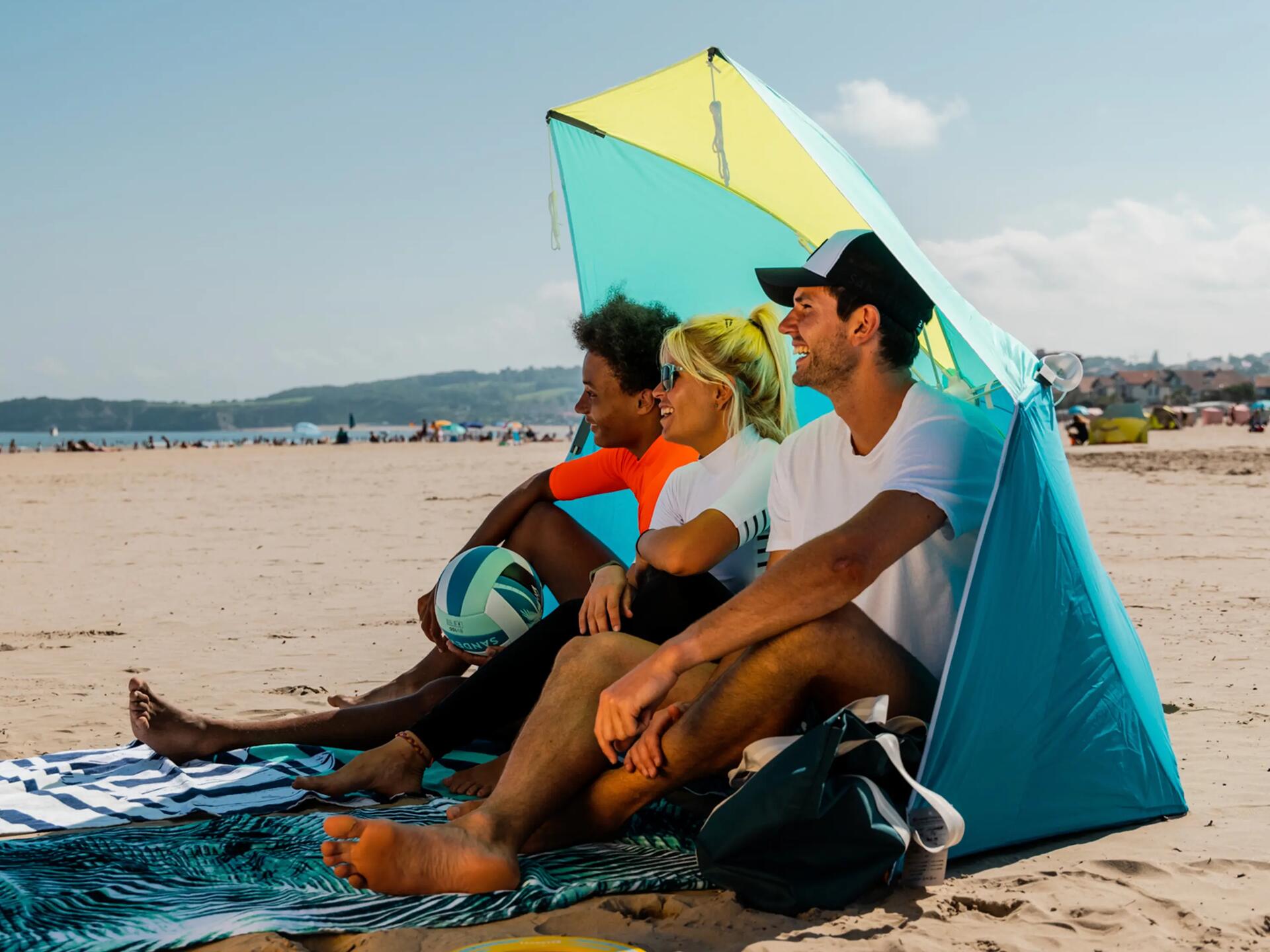 Znajomi siedzący pod parasolem na plaży