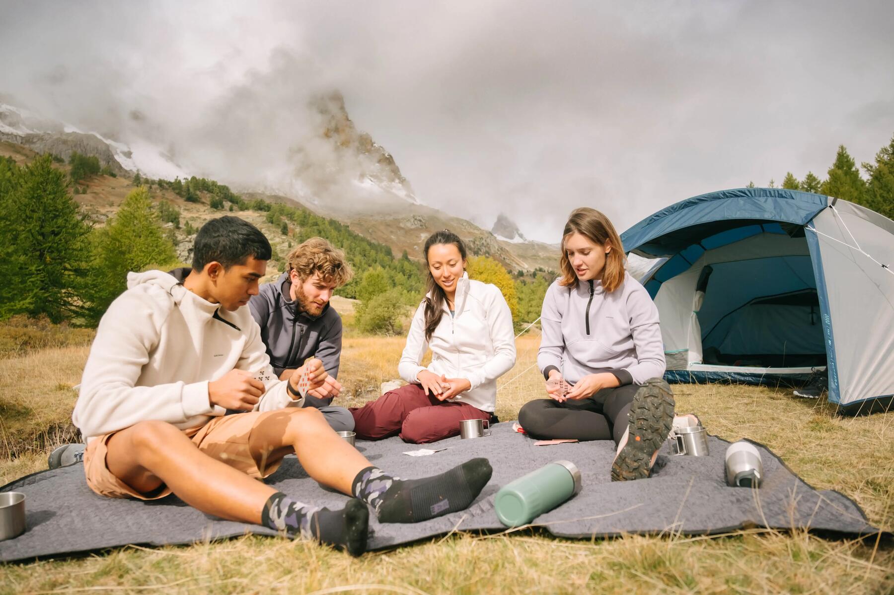 4 personen sitzen auf einer decke