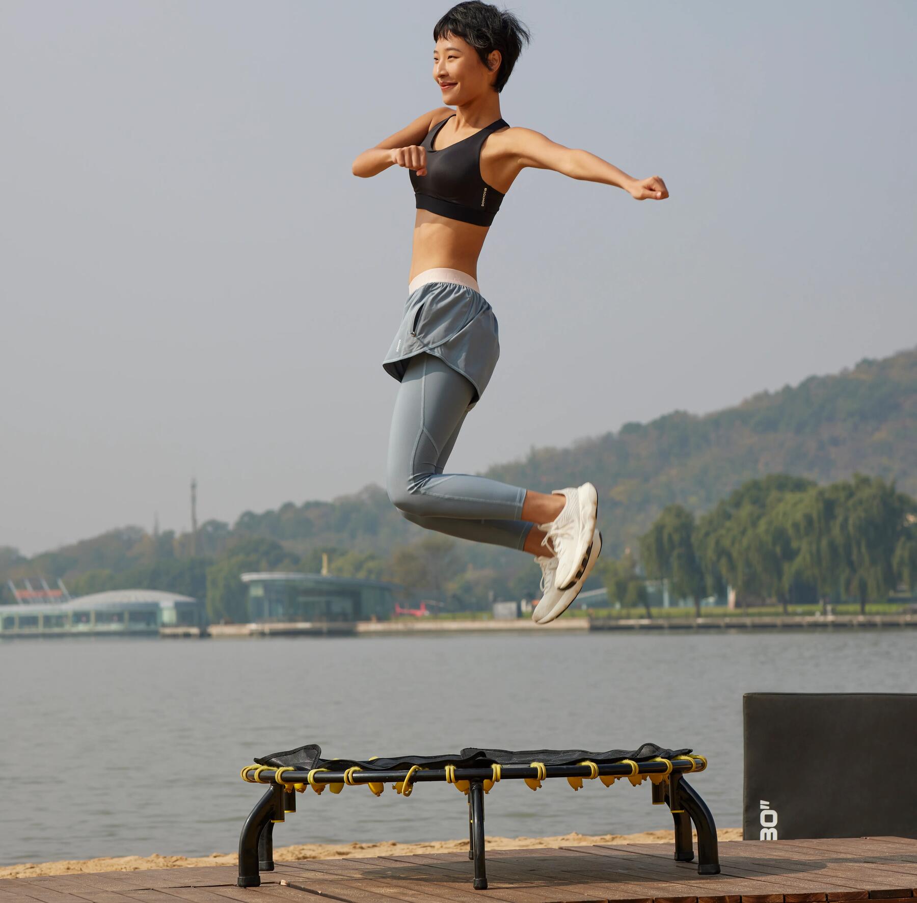 kobieta w stroju sportowym skacząca na trampolinie