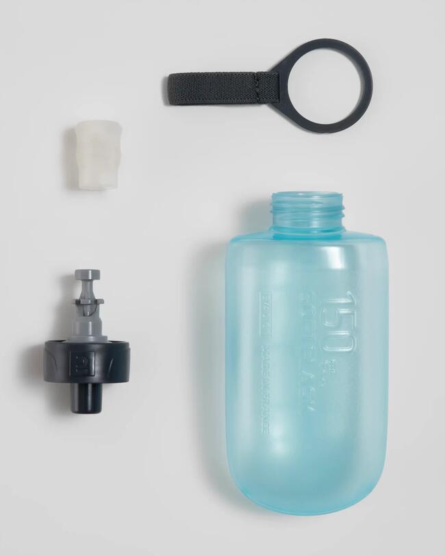 Blaue Trinkflasche mit schwarzem Ring, weißem und schwarzem Verschluss auf grauem Hintergrund.