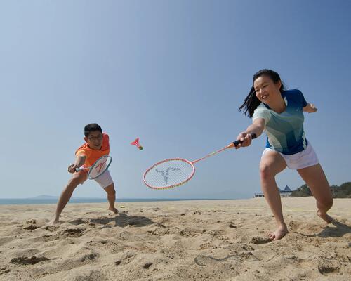 mom and son playing badminton on the beach 
