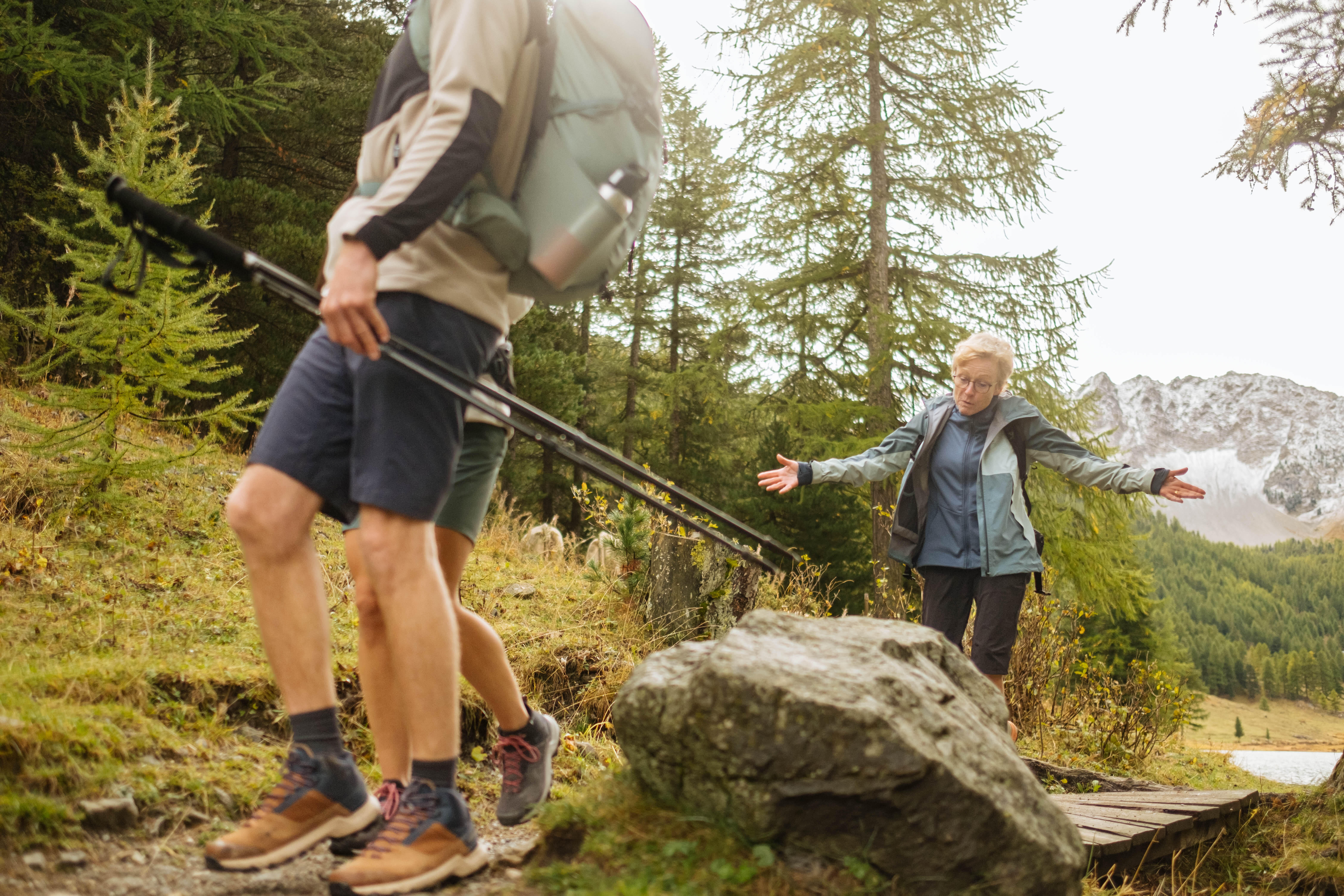 Hikers wearing shorts and backpacks on a rocky mountain trail