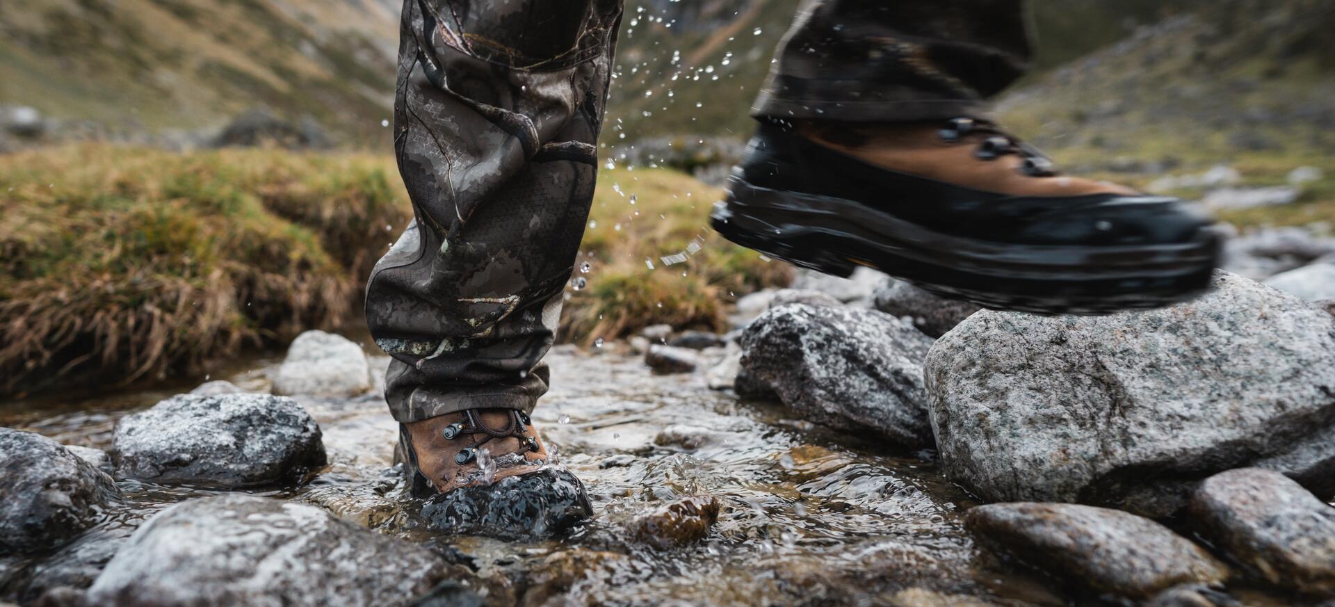 A hunter crosses a stream
