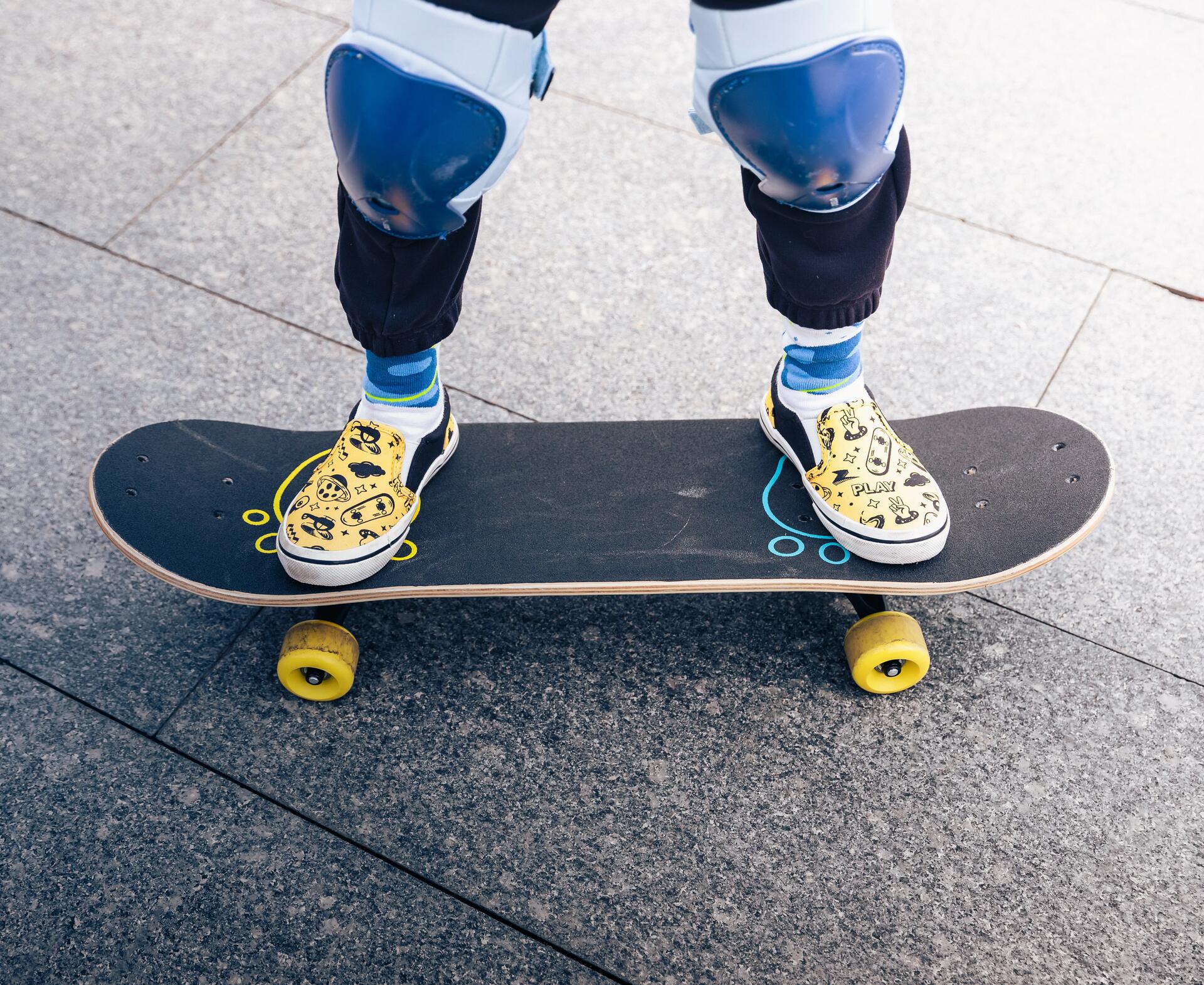 A close of feet and skateboard with both legs on the board