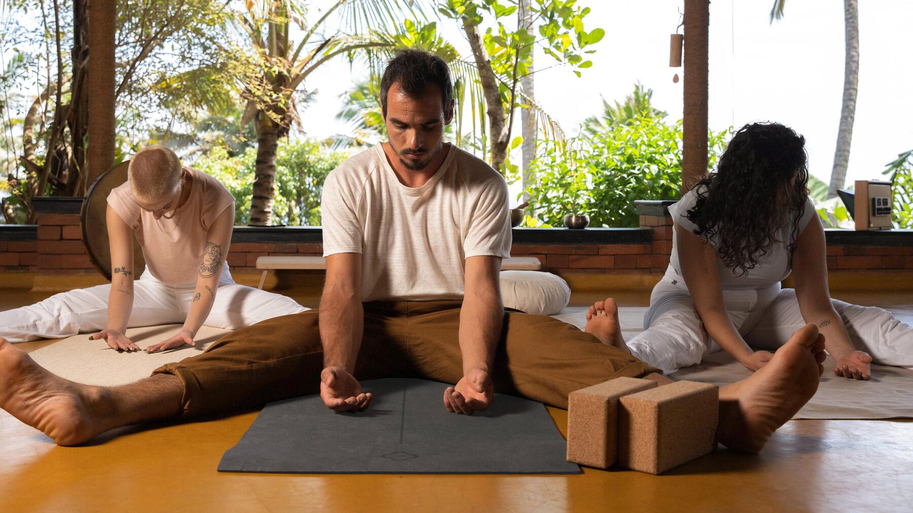 Drei-Personen Gruppe beim Viniyoga auf ihren Yogamatten