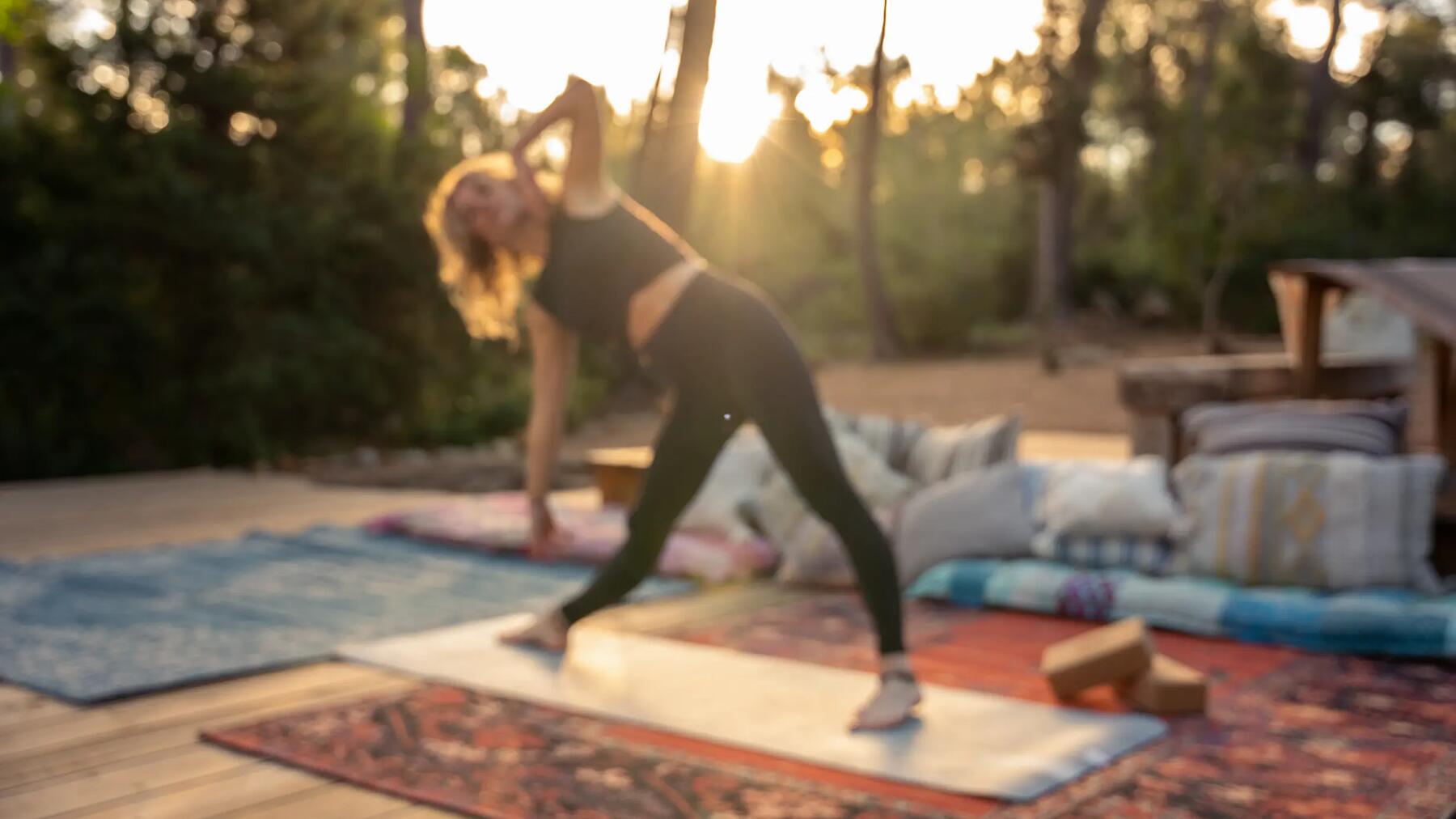 Bei Sonnenaufgang Frau in Yoga Asana draußen im Wald