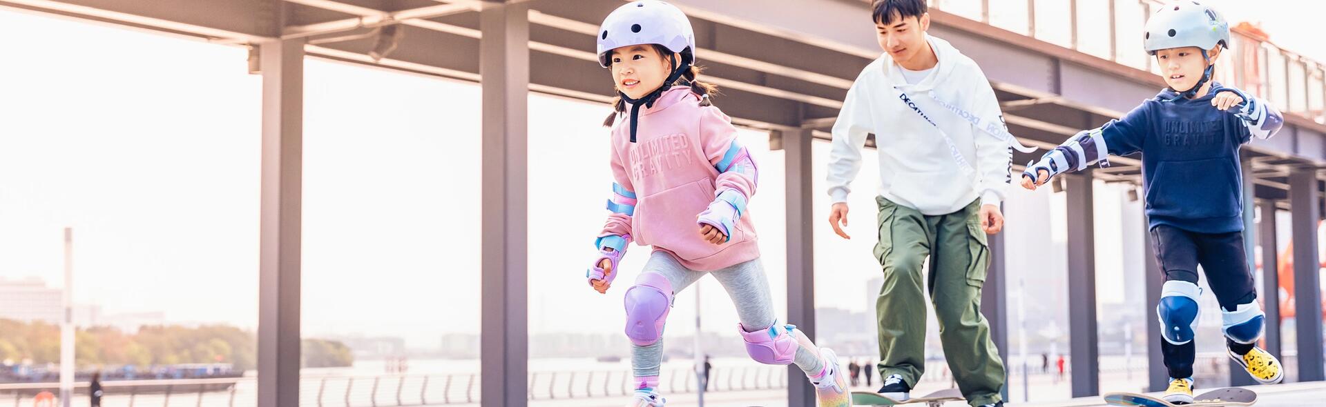 Teenager, younger boy and young girl skateboarding