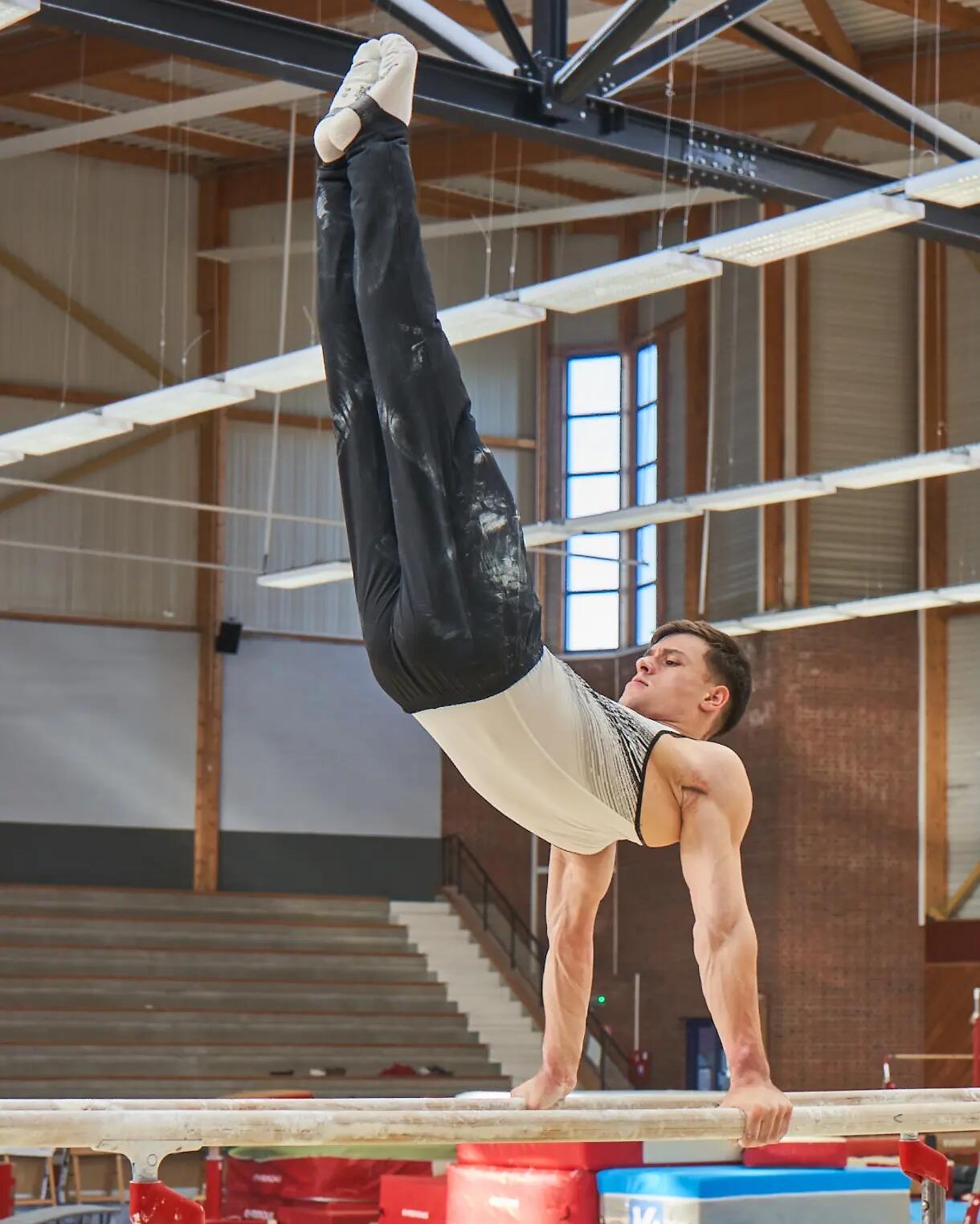 Mężczyzna w getrach sportowych ćwiczący gimnastykę artystyczną