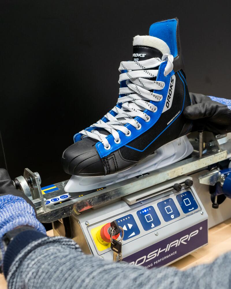 Ein Schlittschuh ist in der Schleifmaschine eingespannt