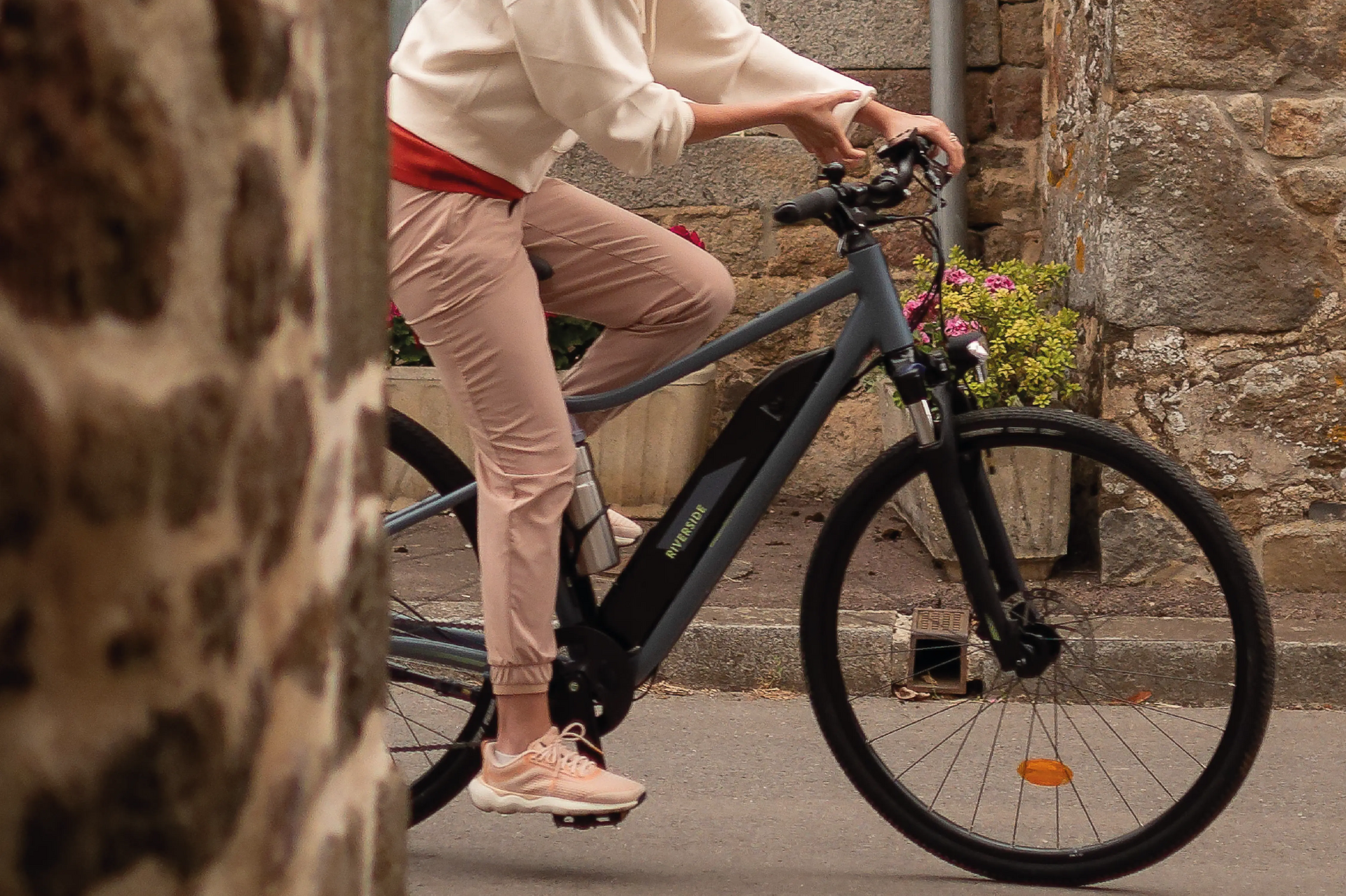 kobieta jadąca na elektrycznym rowerze trekkingowym w stroju sportowym i kasku