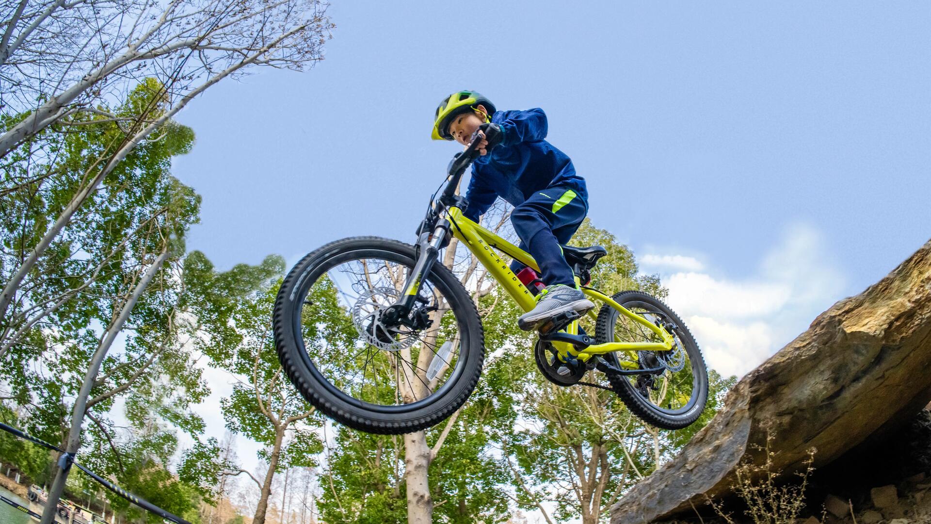 chłopiec skaczący na rowerze MTB w kasku 